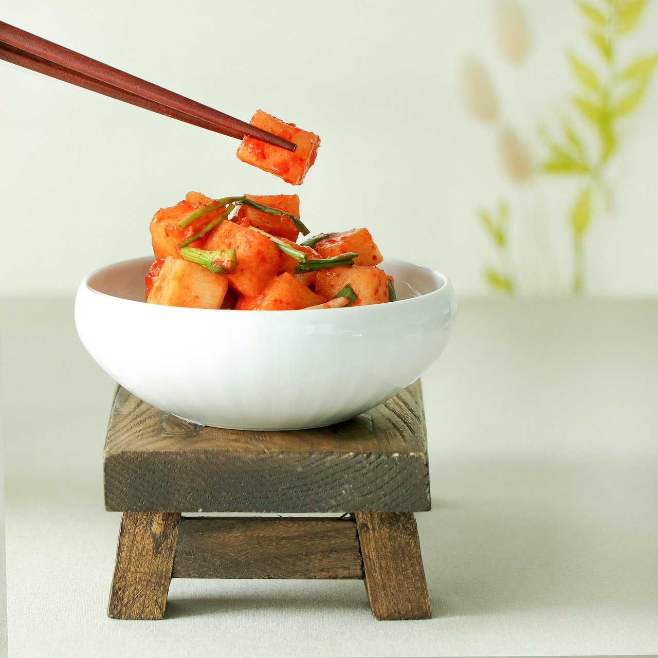 Traditional Korean kimchi in ceramic bowl showing vibrant red fermented cabbage